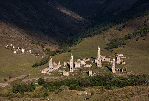 Landscape autumn view of medieval ancient stone battle tower complex in the mountains of Ingushetia, Russia.